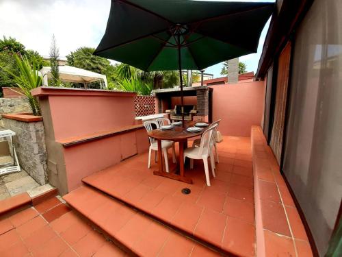 a table and chairs with an umbrella on a patio at Villa Very in Marina di Campo