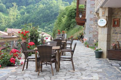 a row of tables and chairs on a stone patio at Posada Sobrevilla in Espinama