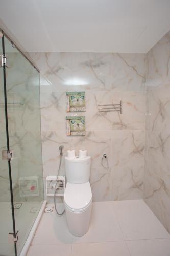 a white bathroom with a toilet and a shower at Bạch Yến T111-Happy Villa Đại Lải Resort in Vĩnh Phúc