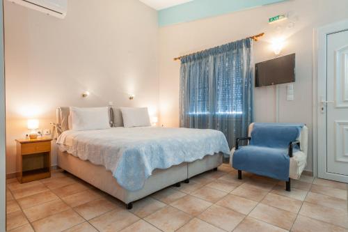 1 dormitorio con 1 cama y 1 silla azul en Alkiones, en Plati