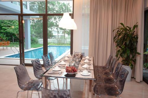 a dining table and chairs in a room with a pool at Bạch Yến T111-Happy Villa Đại Lải Resort in Vĩnh Phúc