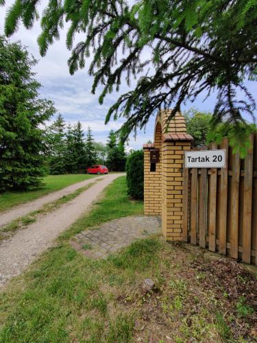 a fence with a sign that readstrack next to a road at Pod bocianim gniazdem in Stary Folwark