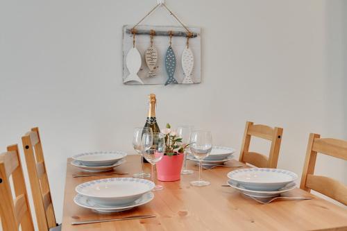 a wooden table with plates and wine glasses on it at TriApart Amber Jantar III in Jantar