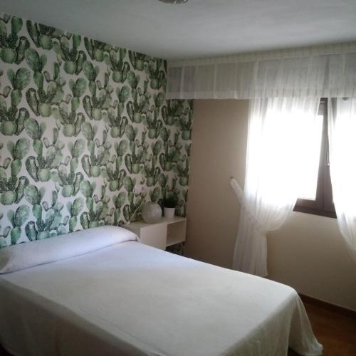 ポルトノボにあるPiso Ubalda Entresueloの緑と白の壁紙を用いたベッドルーム1室