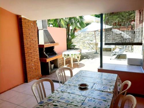 a dining room with a table and a fireplace at Villa Very in Marina di Campo