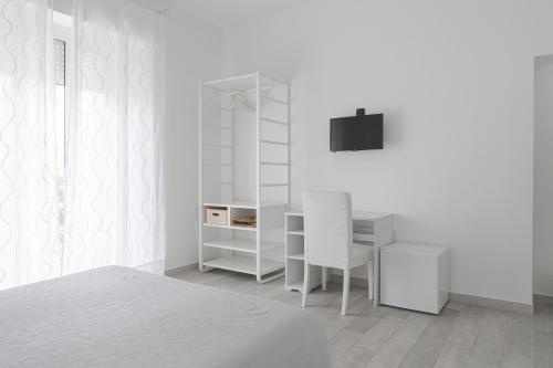 a white bedroom with a bed and a desk at Amare Sirolo in Sirolo