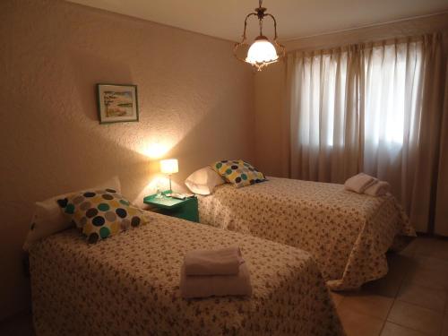 a bedroom with two beds and a chandelier at Angelo di Caneva in Chacras de Coria
