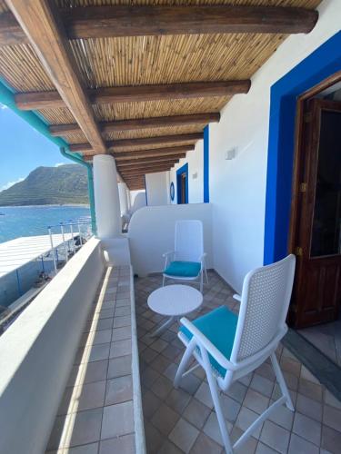 a balcony with chairs and a table and a view of the ocean at Da Nino sul mare Filicudi in Filicudi