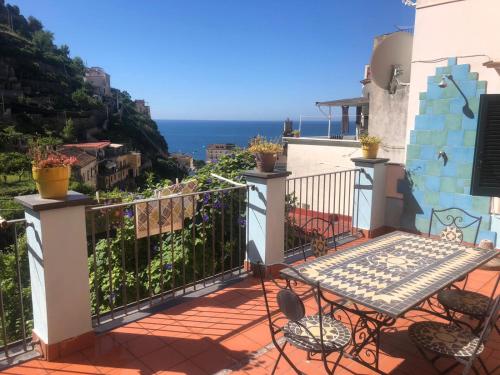 a balcony with a table and chairs overlooking the ocean at Appartamento Residence Costa D'Amalfi in Minori