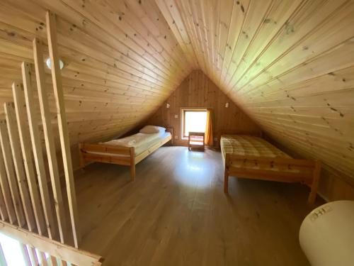 an attic room with two beds and a window at Hörgsland Cottages in Hörgsland