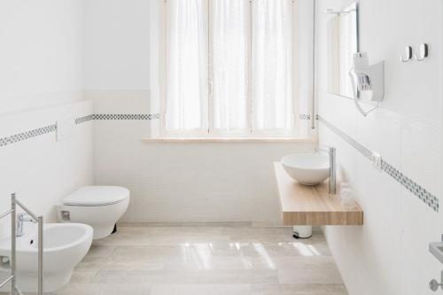 Baño blanco con aseo y lavamanos en Casa Palanca Camere, en Sirolo