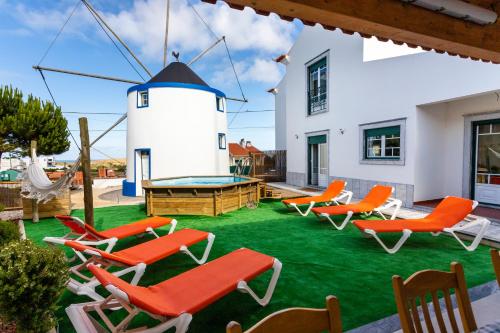 a group of chairs and a pool table and a lighthouse at Casa do moleiro in Encarnação