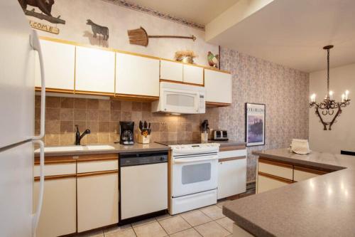 a kitchen with white cabinets and white appliances at Kutuk Condominiums in Steamboat Springs