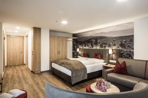 um quarto de hotel com uma cama e um sofá em Hotel Zum Löwen - Al Leone em Meltina