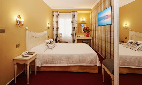 a hotel room with two beds and a mirror at Hôtel Beaubourg in Paris