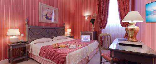 a bedroom with a bed with a table and a desk at Hôtel Beaubourg in Paris