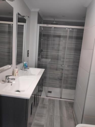 Amplio apartamento con todas las comodidades en Oviedo في أوفِييذو: حمام مع دش ومغسلة بيضاء