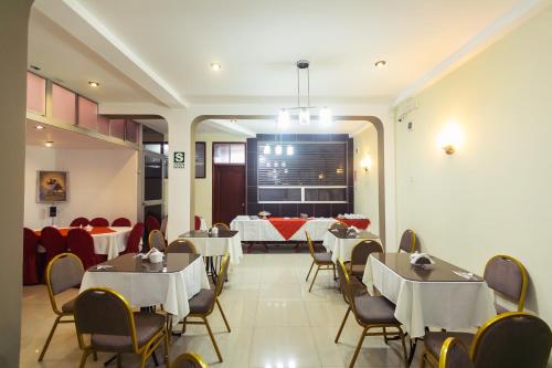 un comedor con mesas y sillas y una sala con mesas y sillas en Hotel Suite Plaza, en Trujillo