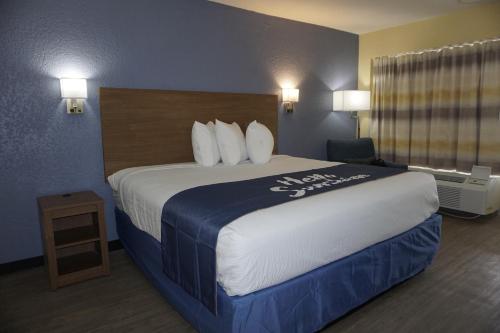 a hotel room with a large bed in a room at Days Inn by Wyndham Apopka/Orlando in Orlando
