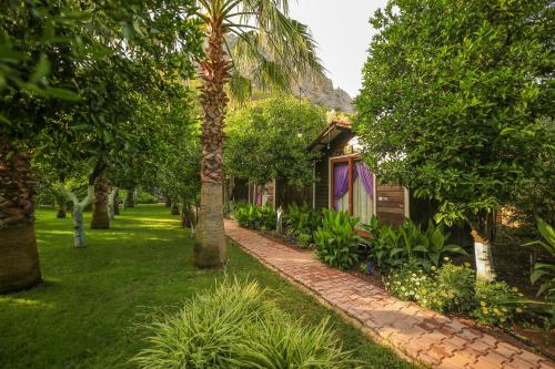 a garden with a brick path next to a house at Likya Evleri Olympos in Olympos