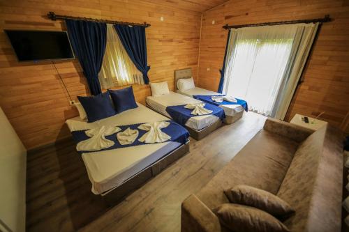 sala de estar con 2 camas y sofá en Likya Evleri Olympos, en Olympos