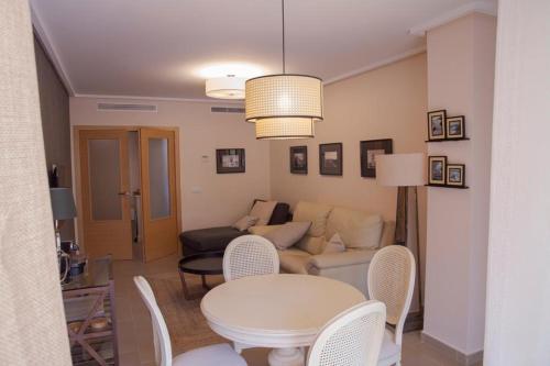 a living room with a couch and a table and chairs at Jardines de las Marinas Premium in Denia