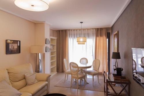 a living room with a couch and a table at Jardines de las Marinas Premium in Denia