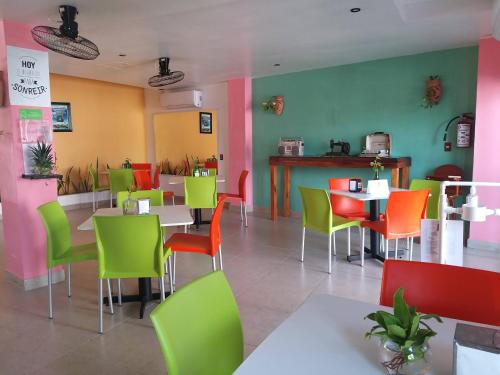 a dining room with colorful chairs and tables in a restaurant at Hotel D Marco Exxpres in Palenque