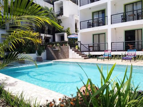 a swimming pool in front of a building at Hotel D Marco Exxpres in Palenque