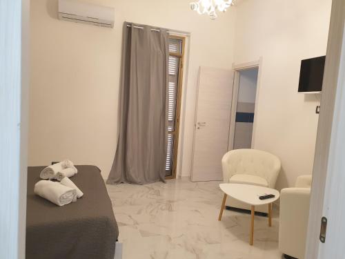 a white room with a bed and a chair at FG Vacanze in Alghero