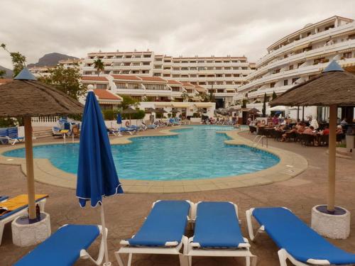 einen Pool mit Liegestühlen und ein Hotel in der Unterkunft Nice apartment on Las Americas Beach in Playa de las Americas