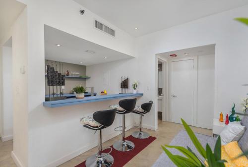 a living room with two stools and a counter at SoBe Lux Suites On Ocean in Miami Beach