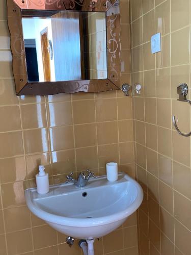 a bathroom with a sink and a mirror at Casinhas Alegria in São Marcos do Campo