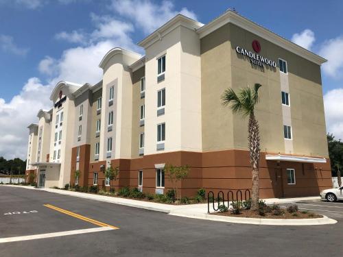 a large building with a palm tree in front of it at Candlewood Suites - Panama City Beach Pier Park, an IHG Hotel in Panama City Beach