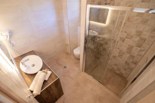 a bathroom with a shower and a sink and a toilet at Melydron Apartments in Preveza