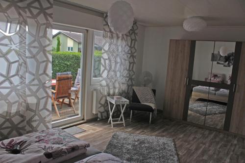 a room with a bed and a mirror and a balcony at FEWO An der Ölmühle in Heuchelheim-Klingen