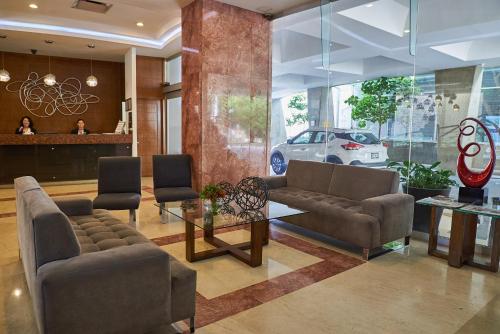 a lobby with couches and a table and a car at Ejecutivo Express Guadalajara Providencia - Av México in Guadalajara