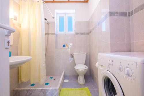 La salle de bains est pourvue de toilettes et d'un lave-linge. dans l'établissement Annetas House, à Néa Koróni
