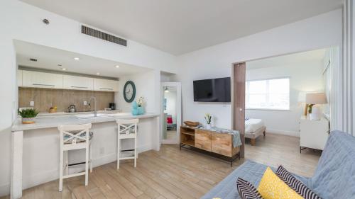 a kitchen and living room with a couch and a table at SoBe Lux Suites On Ocean in Miami Beach