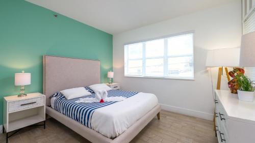 a bedroom with a bed with a teddy bear on it at SoBe Lux Suites On Ocean in Miami Beach