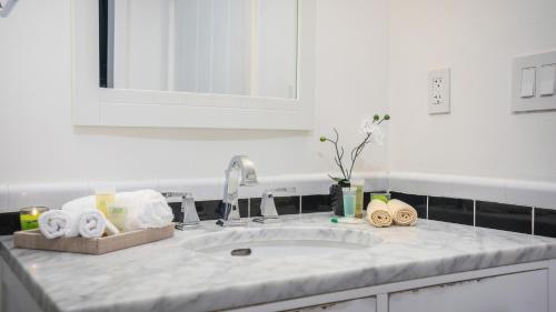 a kitchen counter with a sink with towels on it at SoBe Lux Suites On Ocean in Miami Beach