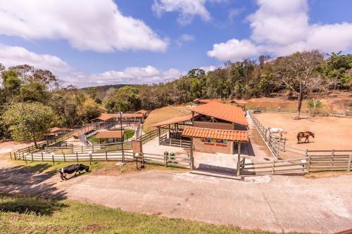 an aerial view of a farm with two horses in a field at Tauá Hotel & Convention Caeté in Caeté