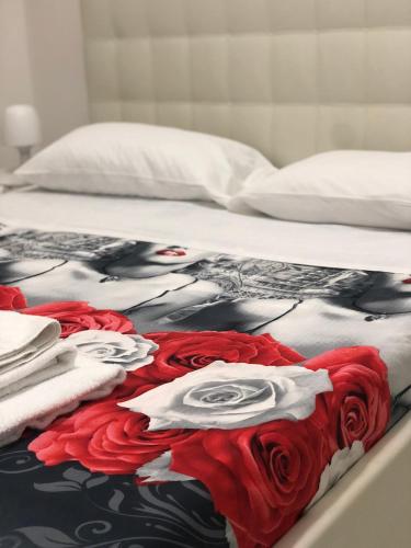 a bed with a blanket with roses on it at Al Porto in Gaeta