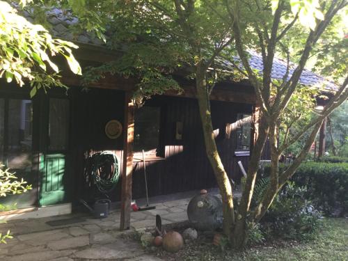 a front porch of a house with a tree at Wohnidylle auf schönem Anwesen im Wald in Bad Honnef am Rhein