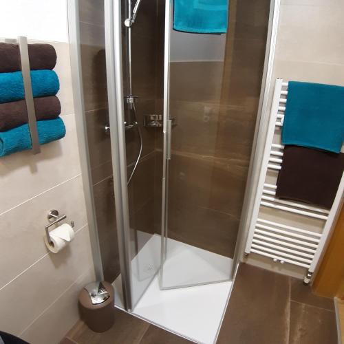 a shower stall in a bathroom with blue towels at Haus Waldfriede in Sankt Leonhard im Pitztal