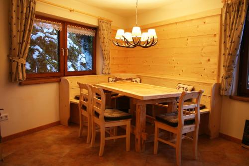 a dining room with a wooden table and chairs at Apartments Landhaus Sonnheim in Lofer