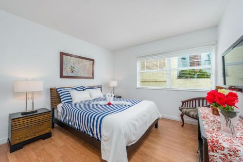 a white bedroom with a bed and a window at SoBe Lux Suites On Ocean in Miami Beach