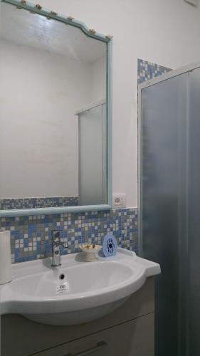 a bathroom with a white sink and a mirror at A casa di Ninuccia in Syracuse