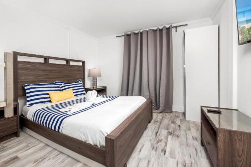 a bedroom with a large bed with a wooden headboard at SoBe Lux Suites On Ocean in Miami Beach