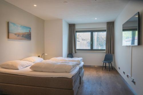 um quarto com 2 camas e uma janela em familiewoning Orchismient 24 em De Koog